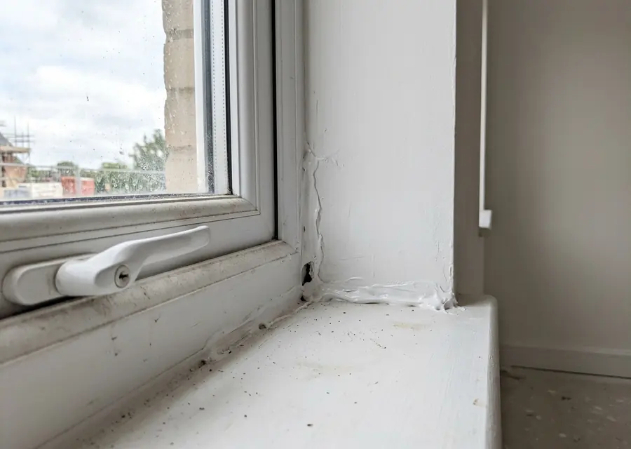 Geöffneter Fußbodenaufbau: Estrichkante, Trennfolie, Dämmung und Rohdecke sichtbar